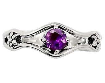 May include: A silver-toned ring featuring a central round-cut purple gemstone set in a polished metal band. The band displays intricate floral-like engravings on both sides of the setting. The text SDR254101 is visible in the upper right corner.