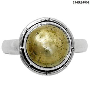 May include: A silver ring featuring a large, round, light-green gemstone. The gemstone is set in a circular bezel with a textured border. The ring's band is a simple, polished silver.