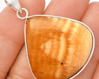 May include: A pendant with a silver bail and a large, teardrop-shaped, orange-brown stone. The stone has a natural, textured pattern with lighter and darker areas. The pendant is likely a piece of jewellery.