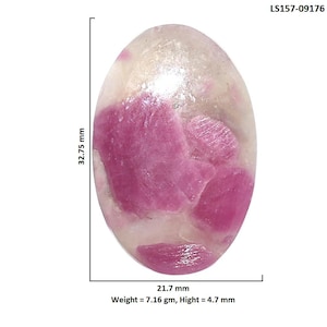 May include: An oval-shaped cabochon gemstone featuring translucent white quartz with embedded vibrant pink ruby inclusions. The stone measures 32.75 mm by 21.7 mm with a height of 4.7 mm and a weight of 7.16 grams. Labeled with code LS157-09176.