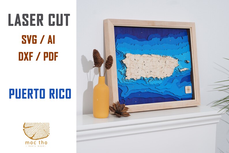 May include: A framed, laser-cut wooden map of Puerto Rico, depicting the island's topography with shades of blue and natural wood. The artwork is displayed on a white surface, with text that reads "LASER CUT" and "PUERTO RICO".