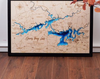 May include: A wooden map of Greers Ferry Lake in Arkansas. The lake is depicted in blue, with the surrounding land in brown. The map includes text labels for various points of interest, including "Greers Ferry Lake", "Arkansas", "Surface area: 40,500 acres", and "Max depth: 198 ft".