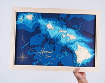May include: A wooden map of the Hawaiian Islands with a blue and brown color scheme. The map is framed in a light wood frame and includes a compass and the text "Hawaii Island".