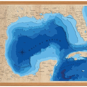 Pu&ograve; includere: Una mappa in legno blu e marrone del Golfo del Messico con indicazioni di profondit&agrave; in piedi. La mappa mostra la costa degli Stati Uniti, del Messico e di Cuba. La mappa &egrave; incorniciata in una cornice di legno marrone chiaro.