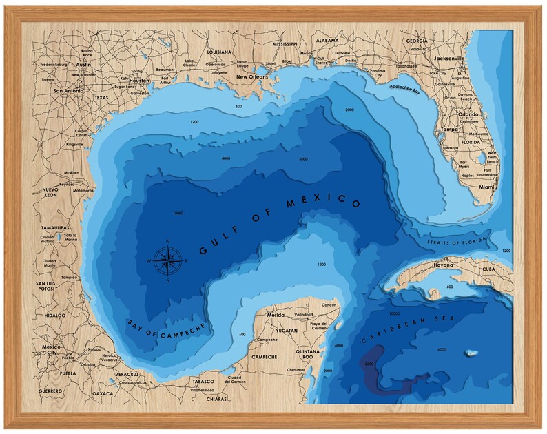 Pu&ograve; includere: Una mappa in legno blu e marrone del Golfo del Messico con indicazioni di profondit&agrave; in piedi. La mappa mostra la costa degli Stati Uniti, del Messico e di Cuba. La mappa &egrave; incorniciata in una cornice di legno marrone chiaro.