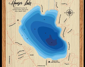 May include: A framed map of Hauser Lake in Kootenai County, Idaho. The map shows the lake's depth contours in shades of blue, with roads and place names labeled. The text includes the lake's surface area of 625 acres and a maximum depth of 38 ft.