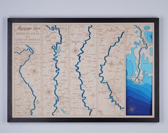 May include: A wooden map of the Mississippi River from St. Louis to the Gulf of Mexico. The map is framed in black and has a blue and white color scheme. The text "Mississippi River from St. Louis to Gulf of Mexico Bill Burlay's Favorite Spot" is printed on the map.