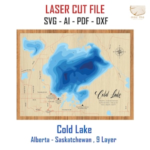 May include: A wooden laser-cut map of Cold Lake, Alberta, and Saskatchewan, with a 9-layer design. The map features blue water depth contours, roads, and a compass rose. The text "Cold Lake" and lake details are displayed.
