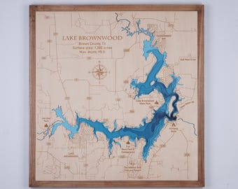 May include: A wooden map of Lake Brownwood in Brown County, Texas. The map shows the lake's depth in shades of blue. The map is framed in a natural wood frame. The text on the map reads "Lake Brownwood, Brown County, TX, Surface area: 7,300 acres, Max. depth: 95 ft."