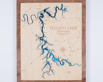 May include: A wooden map of Tellico Lake in Tennessee. The lake is shown in blue, with the surrounding land in brown. The map is framed in a dark wood frame. The text "Tellico Lake, Tennessee, Surface area: 16836 acres, Max. depth: 96 ft" is printed on the map.