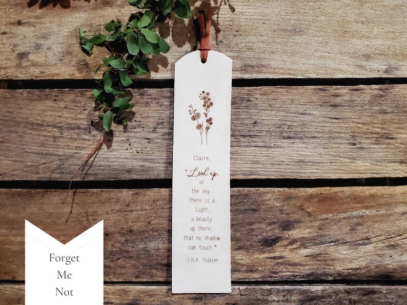 The Forget Me Not flower design.  You can request a name or up to a couple words at the beginning of this note: Look up at the sky.  There is a light, a beauty up there, that no shadow can touch.  -J.R.R. Tolkien.