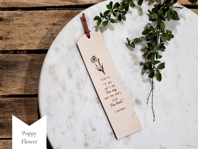 The Poppy Flower design.  You can request a name or up to a couple words at the beginning of this note: If you can't see His way past the tears, trust His heart. -C. Spurgeon.  This bookmark is neutral in color and has a simple, minimalist style.