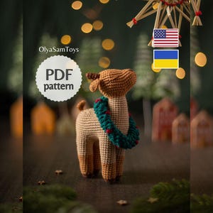 May include: A crochet deer toy with light brown fur, darker brown ears and antlers, and a dark green wreath with small red berries around its neck. The image includes the text OlyaSamToys and PDF pattern, along with American and Ukrainian flag icons.