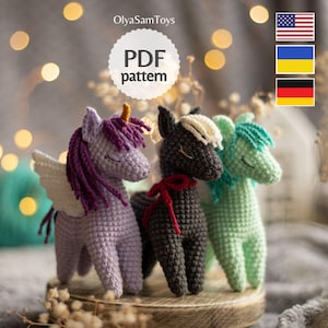 Puede incluir: Tres juguetes de unicornio de ganchillo en tonos morado, negro y verde. El unicornio morado tiene un cuerno dorado y alas blancas. El unicornio negro tiene un lazo rojo. El texto "PDF pattern" está en un círculo blanco.