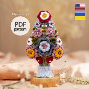 Może przedstawiać: Biały ceramiczny kubek z czarnym uchwytem i napisem "But First, Coffee" pogrubioną czcionką. Kubek jest umieszczony na rozmytym tle, sugerującym przytulne otoczenie.