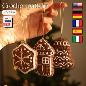 Könnte beinhalten: Häkelanleitung für drei Lebkuchen-Anhänger: ein Lebkuchenhaus, eine Lebkuchen-Glocke und ein Lebkuchen-Schneeflocke. Die Anleitung ist im PDF-Format verfügbar und enthält Anweisungen zur Herstellung der Anhänger in Englisch, Deutsch, Französisch, Spanisch und Italienisch.