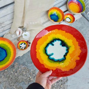 以下が含まれることがあります： 虹のデザインが施されたカラフルなセラミックボウルセット。ボウルは赤、オレンジ、黄色、緑、青、紫の色合いで釉薬がかけられています。ボウルは、スナック、ディップ、サラダの盛り付けに最適です。