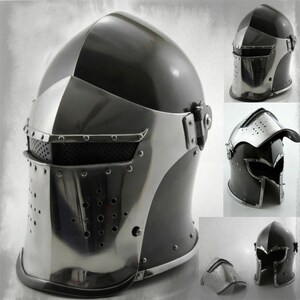 K&ouml;nnte beinhalten: Ein schwarzer und silberner mittelalterlicher Helm mit Visier und einem Maschengesichtschutz. Der Helm hat ein klappbares Visier und einen Maschengesichtschutz. Der Helm ist aus Metall und hat eine schwarze Oberfl&auml;che.