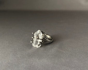 Quartz crystal gemstone prong set in Sterling silver. Artisan hand made ring has a soldered band. A woman’s cocktail ring with metaphysics