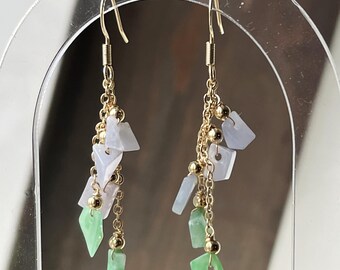 May include: A pair of gold dangle earrings with a chain and multiple green and light blue jade stones.