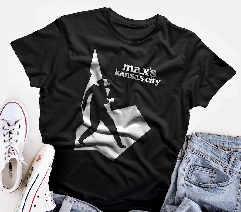 May include: Black t-shirt with a white silhouette of a person walking and the text "max's kansas city" in white.
