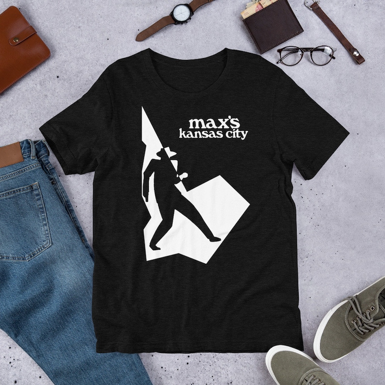 May include: Black t-shirt with a white silhouette of a person wearing a hat and the text "max's kansas city" in white.