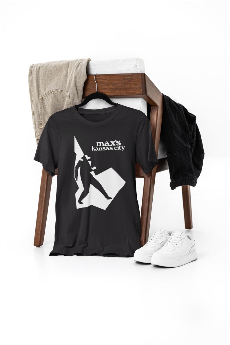 May include: Black t-shirt with a white graphic of a person in a hat and the text "max's kansas city"
