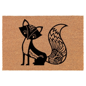 May include: A black and white doormat with a stylized fox design. The fox has a detailed, patterned tail.