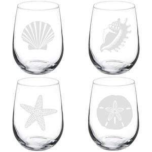 May include: Set of four stemless wine glasses. Each glass features a different etched design of a seashell, conch shell, starfish, and sand dollar. The glasses are clear and ideal for serving wine or other beverages.