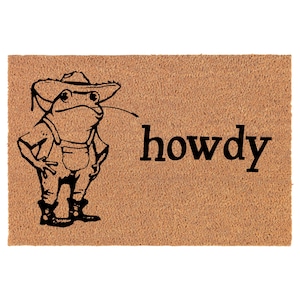 May include: A brown coir doormat with a black cartoon frog wearing a hat and overalls. The text "howdy" is printed in black on the doormat.