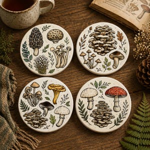 May include: Set of four ceramic coasters featuring detailed illustrations of various mushrooms and foliage. Each coaster has a cream-colored background with a different mushroom design, surrounded by green and brown botanical elements. The coasters are round.
