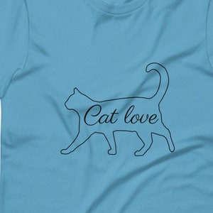 Könnte beinhalten: Ein hellblaues T-Shirt mit einer schwarzen Umrandung einer Katze und dem Text "Cat love" innerhalb der Umrandung.