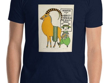 May include: A navy blue t-shirt with a vintage illustration of a yellow goat wearing a green and black patterned blanket. The illustration is accompanied by text that reads "IBEXIATICUS ENSIGNED IN QUEEN CITY PRINTING INK COS INK BEASTS PARADE BY ME."