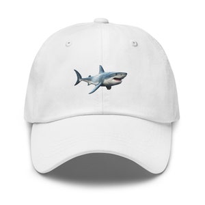 Puede incluir: Gorra de béisbol blanca con una imagen bordada de un gran tiburón blanco.
