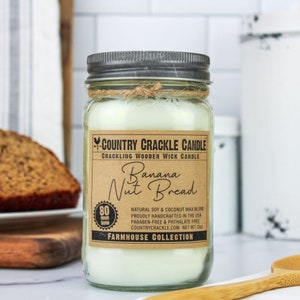 May include: A glass jar candle with a brown label that reads "COUNTRY CRACKLE CANDLE", "CRACKLING WOODEN WICK CANDLE", "Banana Nut Bread", "80 HOUR BURN", "NATURAL SOY & COCONUT WAX BLEND", "PROUDLY HANDCRAFTED IN THE USA", "PARABEN-FREE & PHTHALATE-FREE", "COUNTRYCRACKLE.COM NET WT 12oz", and "FARMHOUSE COLLECTION".