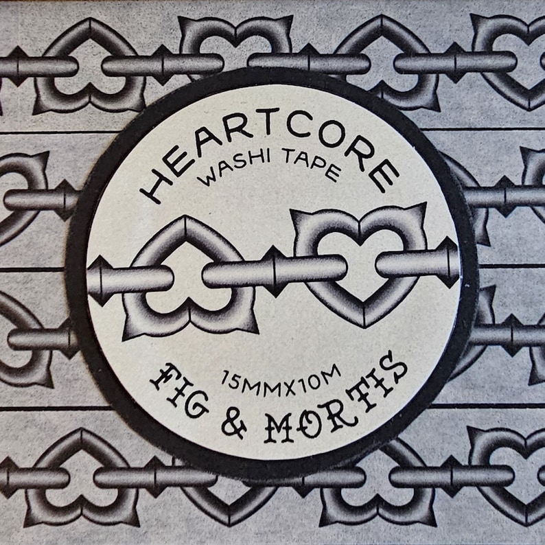 May include: A roll of Heartcore washi tape by Fig & Mortis featuring a repeating black and white pattern of heart-shaped chain links. The circular label displays the text Heartcore Washi Tape and Fig & Mortis with dimensions of 15mm x 10m.