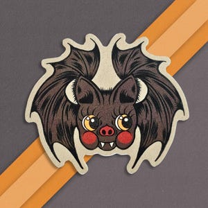 May include: A brown bat with large, black wings and big, round eyes. The bat has a small, pink nose and a toothy grin. The bat is drawn in a cartoon style and has a whimsical, cute appearance.