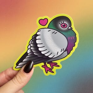 K&ouml;nnte beinhalten: Ein farbenfroher Aufkleber mit einer stilisierten Taube mit einem Herz. Die Taube hat einen schwarzen Kopf, graue Fl&uuml;gel und eine lila Brust, die schwarz umrandet ist. Der Aufkleber befindet sich auf einem gelben Hintergrund mit Farbverlauf.