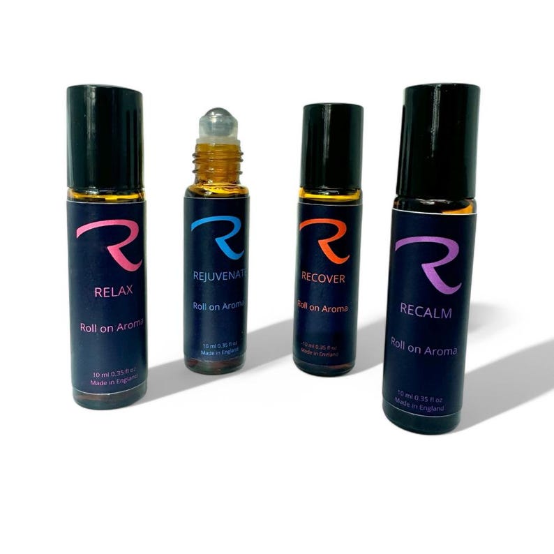 May include: Four 10 ml roll-on essential oil bottles with black caps and labels. The labels feature a stylized letter 'R' and the words 'RELAX', 'REJUVENATE', 'RECOVER', and 'RECALM'. Each bottle says 'Roll on Aroma' and 'Made in England'.