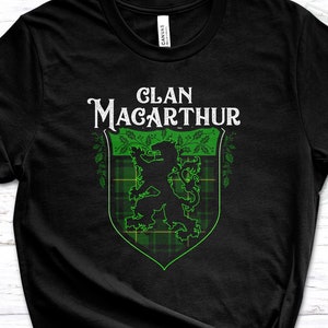 Op de afbeelding: Zwart T-shirt met een groen clanwapen met een leeuw en de tekst "Clan Macarthur".