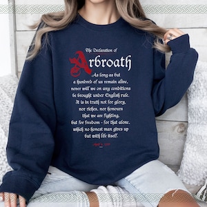 May include: A navy blue sweatshirt with a white print of the Declaration of Arbroath. The text reads: "As long as but a hundred of us remain alive, never will we on any conditions be brought under English rule. It is in truth not for glory, nor riches, nor honours that we are fighting, but for freedom - for that alone, which no honest man gives up but with life itself."