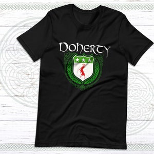 Könnte beinhalten: Schwarzes T-Shirt mit einem grünen und weißen Wappen, das einen roten Hirsch und den Text "Doherty" in Weiß zeigt.