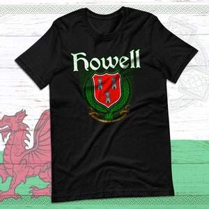 May include: Black t-shirt featuring the name "Howell" in white script above a crest. The crest has a red shield with three silver towers, surrounded by green Celtic knotwork. The shirt design includes the phrase "Virtute et Armis".