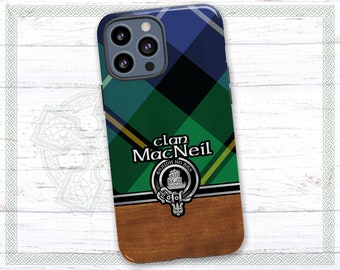 Op de afbeelding: Een telefoonhoesje van groene, blauwe en zwarte ruit met een zilveren clanwapen en de tekst "clan MacNeil" in zwart. Het hoesje heeft een houtnerfpatroon op de onderste helft.