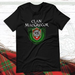 May include: Black t-shirt with a green and red clan crest and the text "Clan MacGregor" in white.