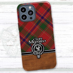 May include: A red, green, and black tartan phone case with a silver and black clan crest featuring a bird and the text "Clan Munro Dread God".