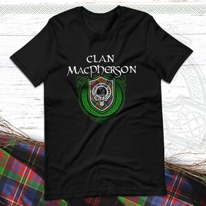 Peut inclure: T-shirt noir avec un blason de clan vert et blanc et le texte "Clan Macpherson" en blanc.