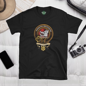 May include: Black t-shirt with a gold and red crest featuring a wolf's head and the text "HUNGQUAM OBLIVISCAR" and "MACGIVER".