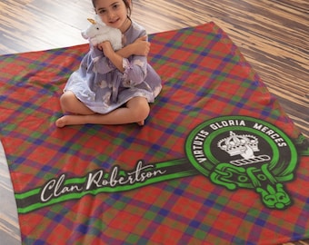 May include: A red, green, and blue plaid fleece blanket with a green and black stripe across the bottom. The stripe has the text "Clan Robertson" in white cursive writing. A green circle with a gold crown, a hand holding a sword, and the text "Virtus Gloria Merces" is on the right side of the blanket.