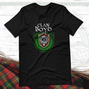 Pode incluir: Camiseta preta com um brasão de clã verde e vermelho e o texto "CLAN BOYO" em branco.